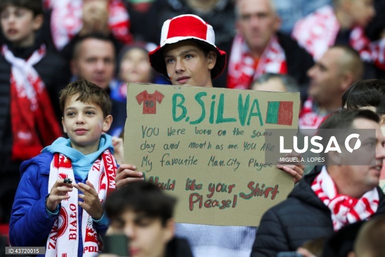 Um adepto exibe um cartaz com o nome do jogador da seleção de Portugal Bernardo Silva (ausente da fotografia), durante o jogo da Fase de Grupos - Grupo 1 - da Liga das Nações da UEFA, Polónia vs Portugal, no Estádio Narodowy, em Varsóvia, Polónia, 12 de outubro de 2024. MIGUEL A. LOPES/LUSA