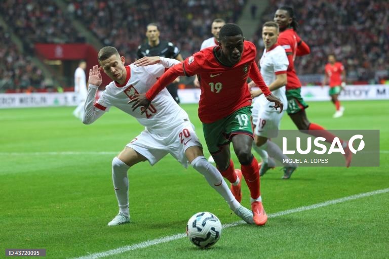 O jogador da seleção da Polónia Sebastian Szymanski (E), disputa a bola com o jogador da seleção de Portugal Nuno Mendes (C), durante o jogo da Fase de Grupos - Grupo 1 - da Liga das Nações da UEFA, Polónia vs Portugal, no Estádio Narodowy, em Varsóvia, Polónia, 12 de outubro de 2024. MIGUEL A. LOPES/LUSA