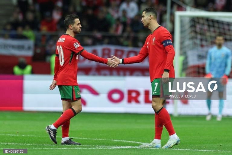 O jogador da seleção de Portugal Bernardo Silva (E) festeja com Cristiano Ronaldo (D) após marcar o 0-1, durante o jogo da Fase de Grupos - Grupo 1 - da Liga das Nações da UEFA, Polónia vs Portugal, no Estádio Narodowy, em Varsóvia, Polónia, 12 de outubro de 2024. MIGUEL A. LOPES/LUSA