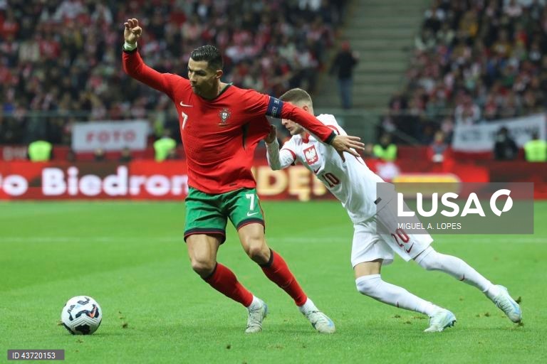 O jogador da seleção da Polónia Sebastian Szymanski (D), disputa a bola com o jogador da seleção de Portugal Cristiano Ronaldo (E), durante o jogo da Fase de Grupos - Grupo 1 - da Liga das Nações da UEFA, Polónia vs Portugal, no Estádio Narodowy, em Varsóvia, Polónia, 12 de outubro de 2024. MIGUEL A. LOPES/LUSA