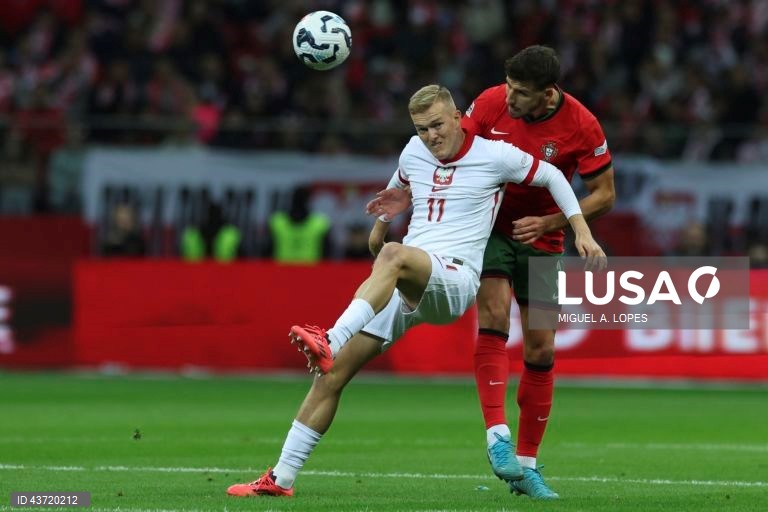 O jogador da seleção da Polónia Karol Swiderski (E), disputa a bola com o jogador da seleção de Portugal Rúben Dias (D), durante o jogo da Fase de Grupos - Grupo 1 - da Liga das Nações da UEFA, Polónia vs Portugal, no Estádio Narodowy, em Varsóvia, Polónia, 12 de outubro de 2024. MIGUEL A. LOPES/LUSA