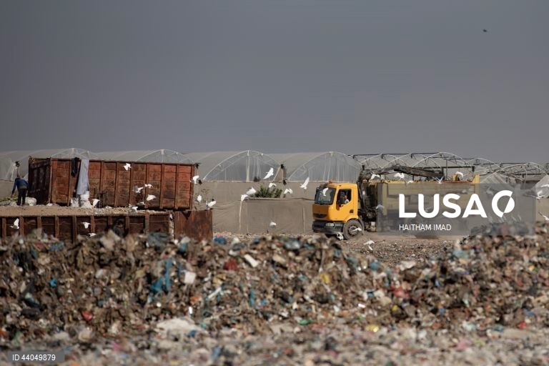 Palestinianos deslocados procuram por bens entre pilhas de lixo perto de Khan Younis