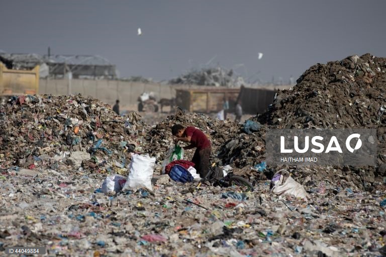 Palestinianos deslocados procuram por bens entre pilhas de lixo perto de Khan Younis