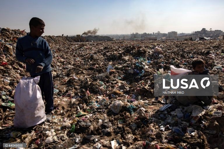 Palestinianos deslocados procuram por bens entre pilhas de lixo perto de Khan Younis