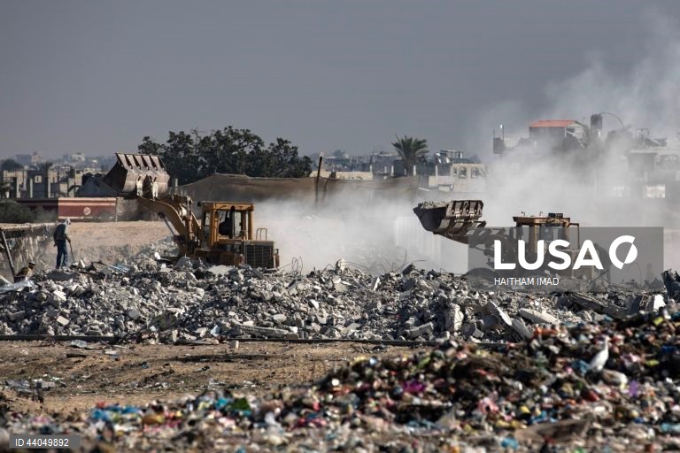 Palestinianos deslocados procuram por bens entre pilhas de lixo perto de Khan Younis