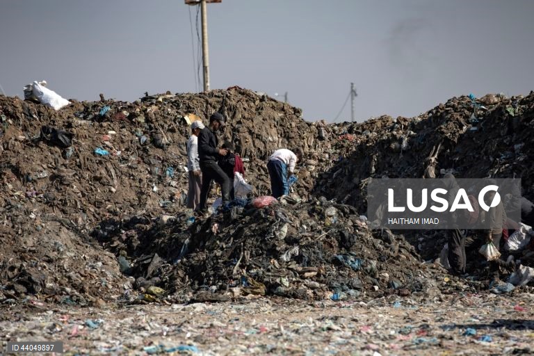 Palestinianos deslocados procuram por bens entre pilhas de lixo perto de Khan Younis