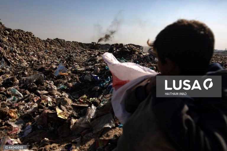 Palestinianos deslocados procuram por bens entre pilhas de lixo perto de Khan Younis