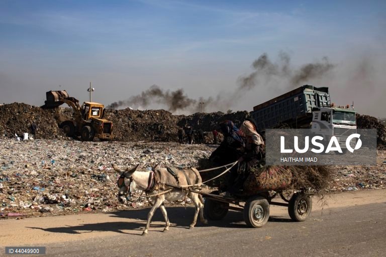 Palestinianos deslocados procuram por bens entre pilhas de lixo perto de Khan Younis