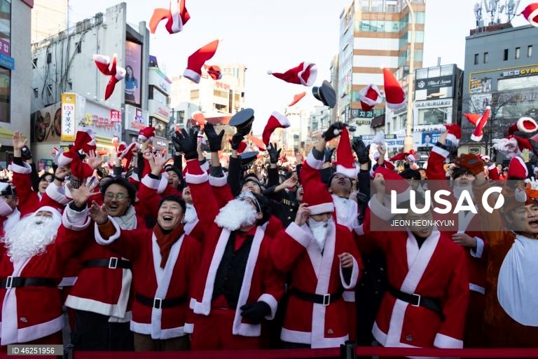Voluntários sul-coreanos vestidos com trajes de Pai Natal participam de um evento beneficente na véspera de Natal em Seul, Coreia do Sul. A Fundação da Juventude da Coreia organizou o evento, distribuindo presentes a 1.004 crianças carentes.  