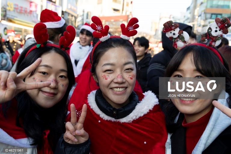 Voluntários sul-coreanos vestidos com trajes de Pai Natal participam de um evento beneficente na véspera de Natal em Seul, Coreia do Sul. A Fundação da Juventude da Coreia organizou o evento, distribuindo presentes a 1.004 crianças carentes.  