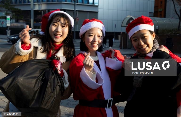 Voluntários sul-coreanos vestidos com trajes de Pai Natal participam de um evento beneficente na véspera de Natal em Seul, Coreia do Sul. A Fundação da Juventude da Coreia organizou o evento, distribuindo presentes a 1.004 crianças carentes.  