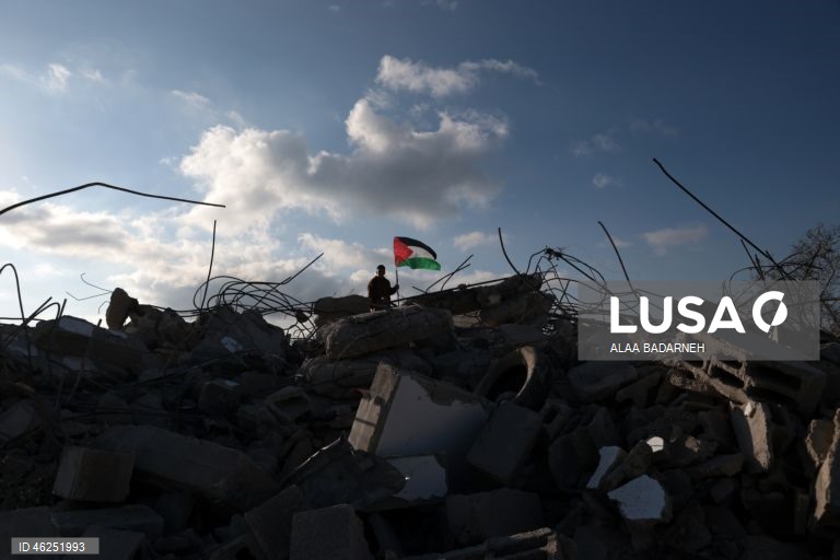 Um menino palestiniano agita uma bandeira palestiniana sobre os escombros da casa pertencente à família de Malik Ismail Salem na aldeia de Bizarya, perto da cidade de Nablus, na Cisjordânia. O exército israelita demoliu a casa de Malik Ismail Salem, que foi morto por tiros israelitas em 10 de julho de 2025, de acordo com a agência de notícias palestiniana WAFA.