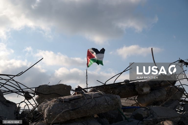 Um menino palestiniano agita uma bandeira palestiniana sobre os escombros da casa pertencente à família de Malik Ismail Salem na aldeia de Bizarya, perto da cidade de Nablus, na Cisjordânia. O exército israelita demoliu a casa de Malik Ismail Salem, que foi morto por tiros israelitas em 10 de julho de 2025, de acordo com a agência de notícias palestiniana WAFA.