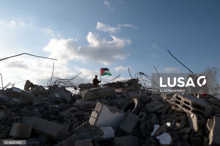 Um menino palestiniano agita uma bandeira palestiniana sobre os escombros da casa pertencente à família de Malik Ismail Salem na aldeia de Bizarya, perto da cidade de Nablus, na Cisjordânia. O exército israelita demoliu a casa de Malik Ismail Salem, que foi morto por tiros israelitas em 10 de julho de 2025, de acordo com a agência de notícias palestiniana WAFA.