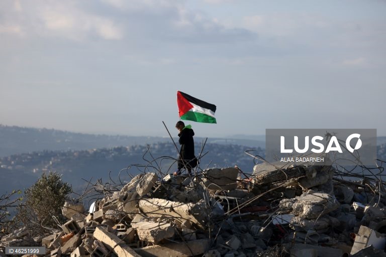 Um menino palestiniano agita uma bandeira palestiniana sobre os escombros da casa pertencente à família de Malik Ismail Salem na aldeia de Bizarya, perto da cidade de Nablus, na Cisjordânia. O exército israelita demoliu a casa de Malik Ismail Salem, que foi morto por tiros israelitas em 10 de julho de 2025, de acordo com a agência de notícias palestiniana WAFA.