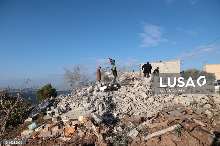 Um menino palestiniano agita uma bandeira palestiniana sobre os escombros da casa pertencente à família de Malik Ismail Salem na aldeia de Bizarya, perto da cidade de Nablus, na Cisjordânia. O exército israelita demoliu a casa de Malik Ismail Salem, que foi morto por tiros israelitas em 10 de julho de 2025, de acordo com a agência de notícias palestiniana WAFA.