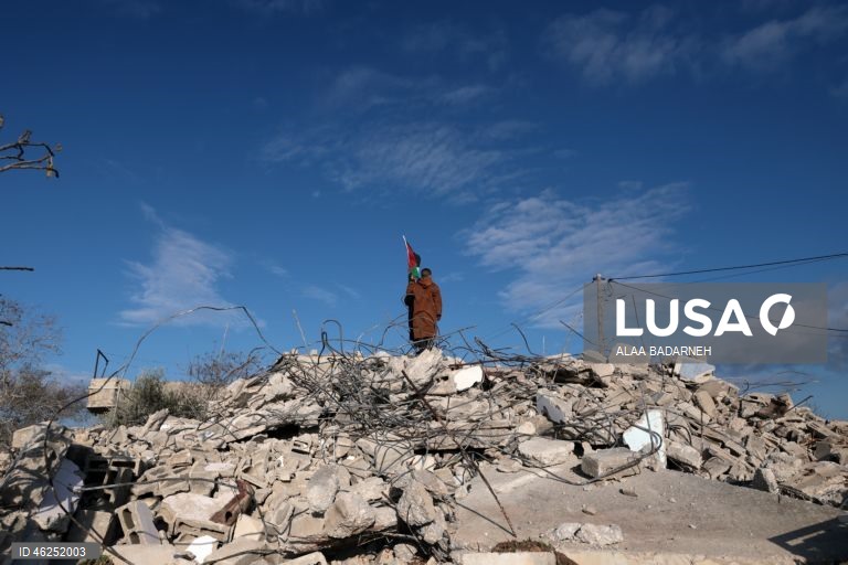 Um menino palestiniano agita uma bandeira palestiniana sobre os escombros da casa pertencente à família de Malik Ismail Salem na aldeia de Bizarya, perto da cidade de Nablus, na Cisjordânia. O exército israelita demoliu a casa de Malik Ismail Salem, que foi morto por tiros israelitas em 10 de julho de 2025, de acordo com a agência de notícias palestiniana WAFA.