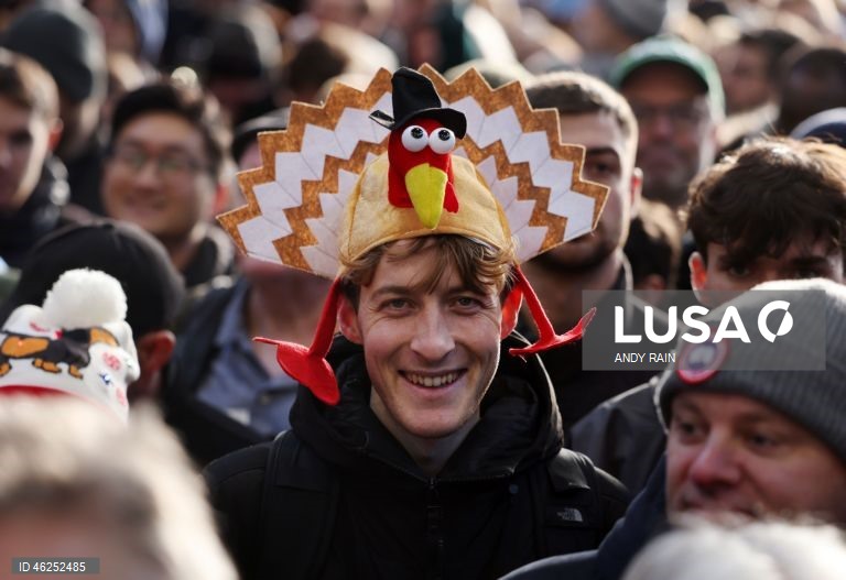 Pessoas observam enquanto talhantes distribuem carne no leilão de carne de Natal em Smithfield, Londres, Grã-Bretanha. Centenas de pessoas reunem-se para ter a oportunidade de comprar carne a preços promocionais na véspera de Natal no mercado de Smithfield, em Londres.