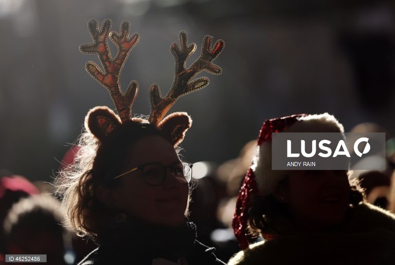 Pessoas observam enquanto talhantes distribuem carne no leilão de carne de Natal em Smithfield, Londres, Grã-Bretanha. Centenas de pessoas reunem-se para ter a oportunidade de comprar carne a preços promocionais na véspera de Natal no mercado de Smithfield, em Londres.