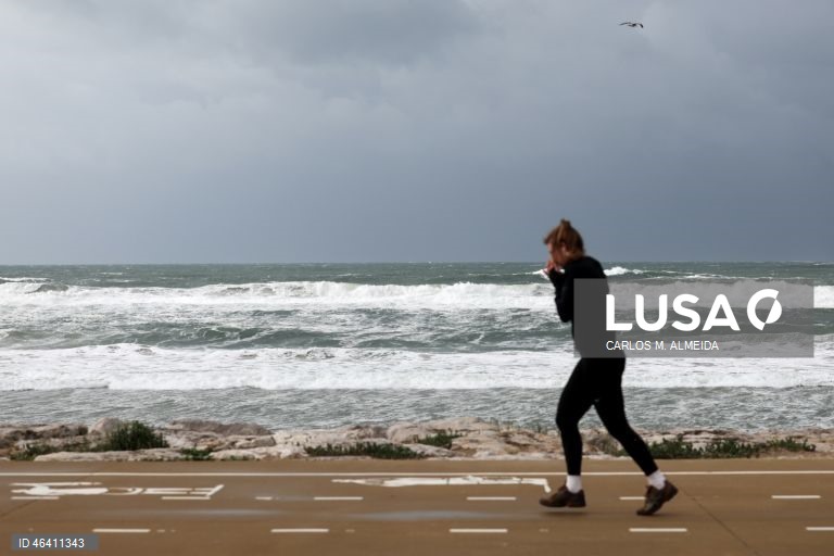 Uma mulher pratica desporto durante a passagem da depressão Ingrid, em Costa de Caparica, 23 de janeiro de 2026. O agravamento das condições meteorológicas causado pela passagem da tempestade Ingrid pelo território continental de Portugal levou ao encerramento de dezenas de escolas na sexta-feira, especialmente na região norte. CARLOS M. ALMEIDA/LUSA