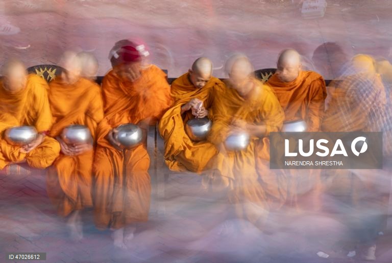 Monges budistas nepaleses à espera de donativos enquanto os peregrinos visitam a Estupa de Boudha durante as celebrações do aniversário de Buda em Catmandu, Nepal. Milhares de devotos budistas e hindus acorreram ao templo para celebrar o tradicional aniversário de Buda, ou Príncipe Siddhartha Gautama, que nasceu há cerca de 2.500 anos em Lumbini, atualmente no Nepal, e é venerado por pessoas em toda a Ásia.  