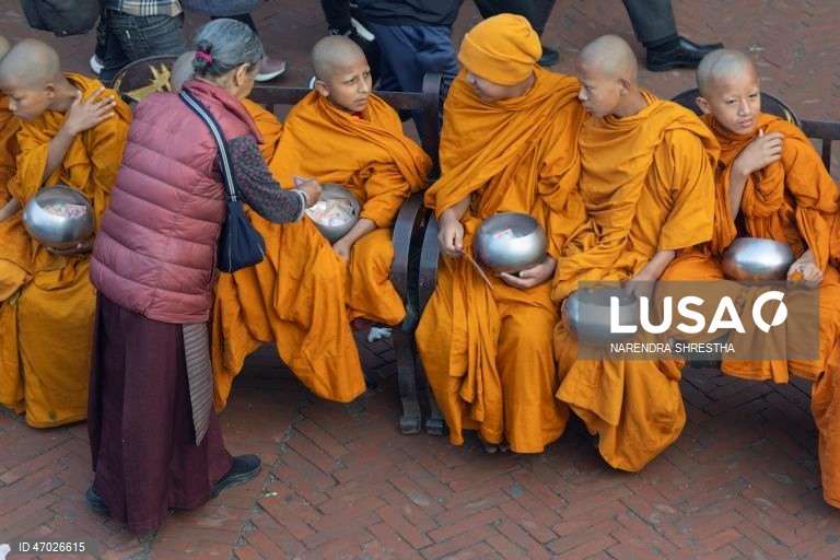 Monges budistas nepaleses à espera de donativos enquanto os peregrinos visitam a Estupa de Boudha durante as celebrações do aniversário de Buda em Catmandu, Nepal. Milhares de devotos budistas e hindus acorreram ao templo para celebrar o tradicional aniversário de Buda, ou Príncipe Siddhartha Gautama, que nasceu há cerca de 2.500 anos em Lumbini, atualmente no Nepal, e é venerado por pessoas em toda a Ásia.  