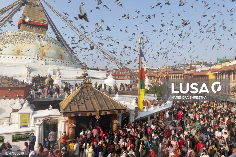 Monges budistas nepaleses à espera de donativos enquanto os peregrinos visitam a Estupa de Boudha durante as celebrações do aniversário de Buda em Catmandu, Nepal. Milhares de devotos budistas e hindus acorreram ao templo para celebrar o tradicional aniversário de Buda, ou Príncipe Siddhartha Gautama, que nasceu há cerca de 2.500 anos em Lumbini, atualmente no Nepal, e é venerado por pessoas em toda a Ásia.  