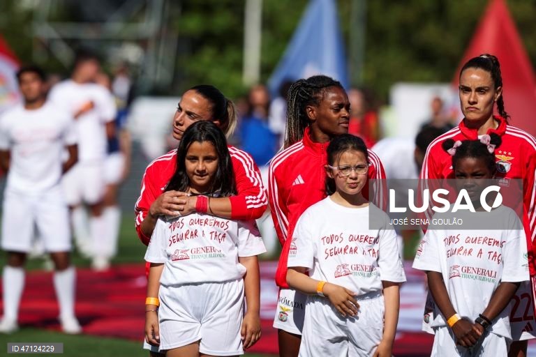A jogadora do Benfica Lúcia Alves (E), abraça uma criança antes do jogo da final da Taça de Portugal feminina de futebol contra o FC Porto, disputado no Estádio do Jamor, em Oeiras, 17 de maio de 2026. JOSÉ SENA GOULÃO/LUSA