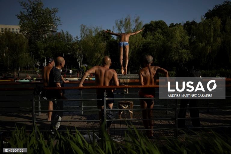 Pessoas utilizam barcos insufláveis e pranchas de remo no rio Liangma, em Pequim, China, a 30 de maio de 2026.  