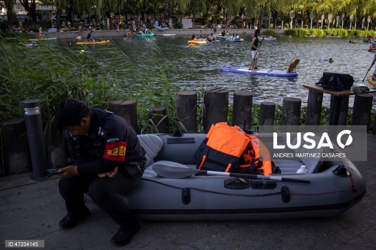 Pessoas utilizam barcos insufláveis e pranchas de remo no rio Liangma, em Pequim, China, a 30 de maio de 2026.  