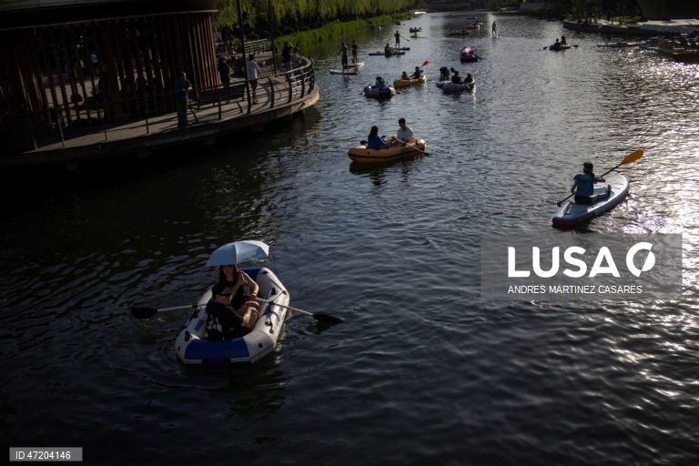 Pessoas utilizam barcos insufláveis e pranchas de remo no rio Liangma, em Pequim, China, a 30 de maio de 2026.  