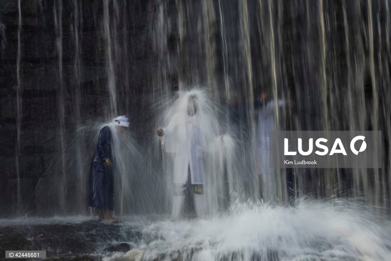Peregrinos purificam-se de espíritos malignos durante um ritual de domingo de manhã numa cascata no rio Braamfontein Spruit em Joanesburgo, África do Sul. A cascata é utilizada sobretudo aos fins-de-semana, quando os peregrinos vêm purificar-se segundo uma tradição antiga. A religião sul-africana baseia-se frequentemente em valores tribais e utiliza as raízes xamânicas como o seu sistema de valores fundamentais. 

