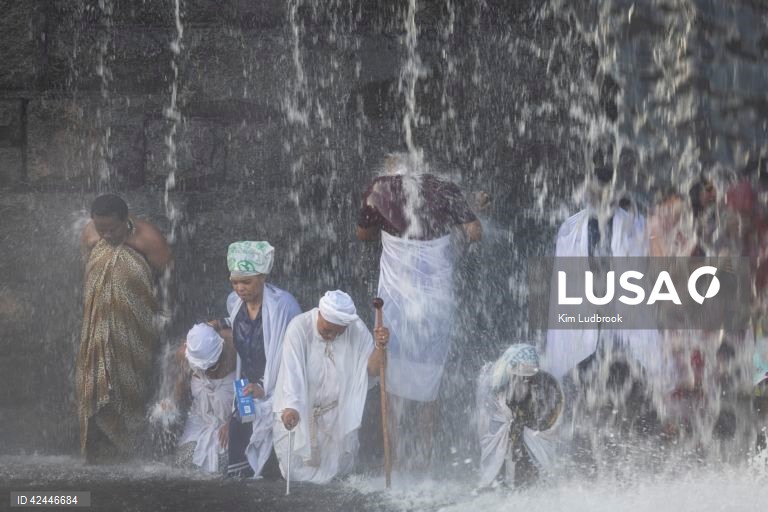 Peregrinos purificam-se de espíritos malignos durante um ritual de domingo de manhã numa cascata no rio Braamfontein Spruit em Joanesburgo, África do Sul. A cascata é utilizada sobretudo aos fins-de-semana, quando os peregrinos vêm purificar-se segundo uma tradição antiga. A religião sul-africana baseia-se frequentemente em valores tribais e utiliza as raízes xamânicas como o seu sistema de valores fundamentais. 

