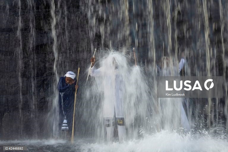 Peregrinos purificam-se de espíritos malignos durante um ritual de domingo de manhã numa cascata no rio Braamfontein Spruit em Joanesburgo, África do Sul. A cascata é utilizada sobretudo aos fins-de-semana, quando os peregrinos vêm purificar-se segundo uma tradição antiga. A religião sul-africana baseia-se frequentemente em valores tribais e utiliza as raízes xamânicas como o seu sistema de valores fundamentais. 

