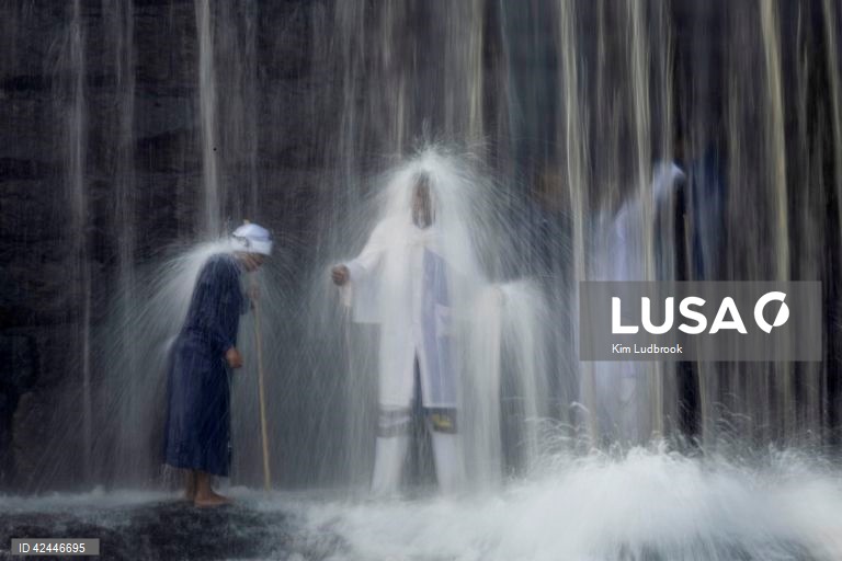Peregrinos purificam-se de espíritos malignos durante um ritual de domingo de manhã numa cascata no rio Braamfontein Spruit em Joanesburgo, África do Sul. A cascata é utilizada sobretudo aos fins-de-semana, quando os peregrinos vêm purificar-se segundo uma tradição antiga. A religião sul-africana baseia-se frequentemente em valores tribais e utiliza as raízes xamânicas como o seu sistema de valores fundamentais. 

