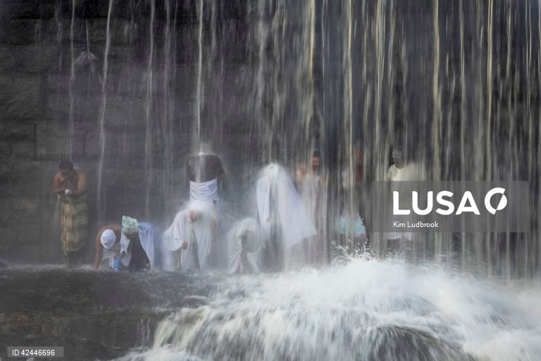 Peregrinos purificam-se de espíritos malignos durante um ritual de domingo de manhã numa cascata no rio Braamfontein Spruit em Joanesburgo, África do Sul. A cascata é utilizada sobretudo aos fins-de-semana, quando os peregrinos vêm purificar-se segundo uma tradição antiga. A religião sul-africana baseia-se frequentemente em valores tribais e utiliza as raízes xamânicas como o seu sistema de valores fundamentais. 

