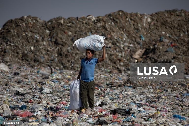 Palestinianos deslocados procuram por bens entre pilhas de lixo perto de Khan Younis