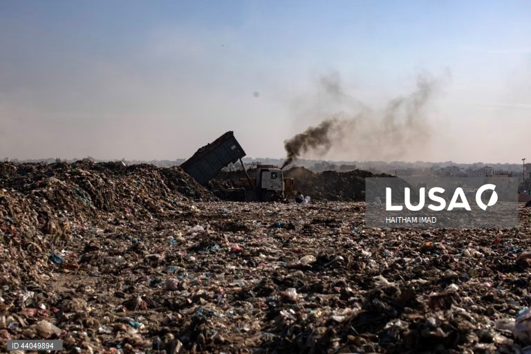 Palestinianos deslocados procuram por bens entre pilhas de lixo perto de Khan Younis