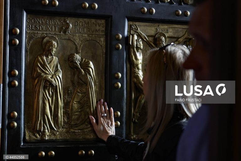 Fiéis passam a porta santa da Basílica de São Pedro