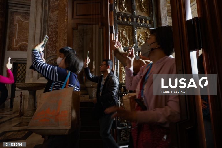 Fiéis passam a porta santa da Basílica de São Pedro