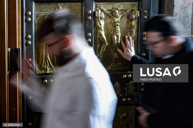 Fiéis passam a porta santa da Basílica de São Pedro