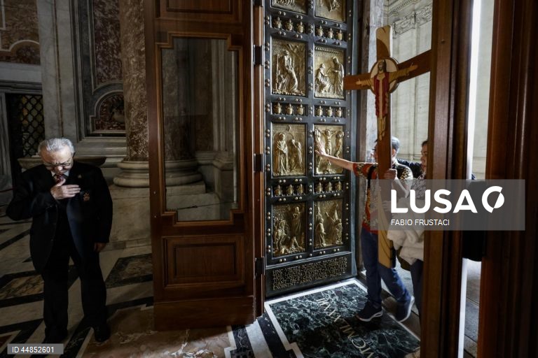 Fiéis passam a porta santa da Basílica de São Pedro