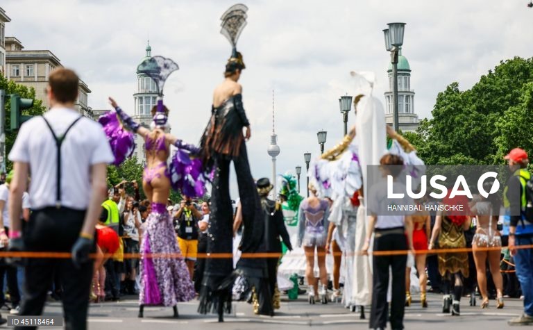 Pessoas vestem trajes tradicionais enquanto participam no Carnaval das Culturas em Berlim, Alemanha. O desfile envolve mais de 4 000 participantes que exibem as culturas dos seus países de origem. O Carnaval das Culturas é celebrado anualmente em Berlim desde 1996 e pretende ser um símbolo da diversidade e da coexistência pacífica. 