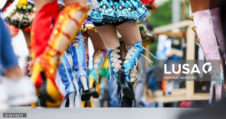 Pessoas vestem trajes tradicionais enquanto participam no Carnaval das Culturas em Berlim, Alemanha. O desfile envolve mais de 4 000 participantes que exibem as culturas dos seus países de origem. O Carnaval das Culturas é celebrado anualmente em Berlim desde 1996 e pretende ser um símbolo da diversidade e da coexistência pacífica. 