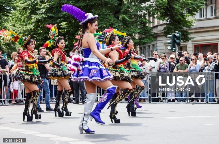 Pessoas vestem trajes tradicionais enquanto participam no Carnaval das Culturas em Berlim, Alemanha. O desfile envolve mais de 4 000 participantes que exibem as culturas dos seus países de origem. O Carnaval das Culturas é celebrado anualmente em Berlim desde 1996 e pretende ser um símbolo da diversidade e da coexistência pacífica. 