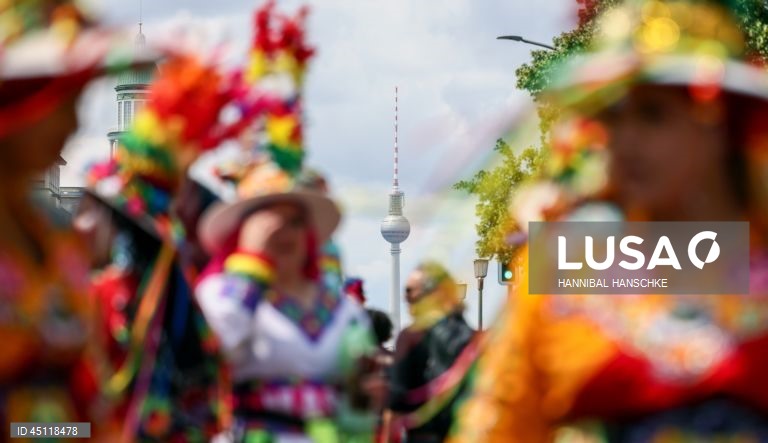 Pessoas vestem trajes tradicionais enquanto participam no Carnaval das Culturas em Berlim, Alemanha. O desfile envolve mais de 4 000 participantes que exibem as culturas dos seus países de origem. O Carnaval das Culturas é celebrado anualmente em Berlim desde 1996 e pretende ser um símbolo da diversidade e da coexistência pacífica. 