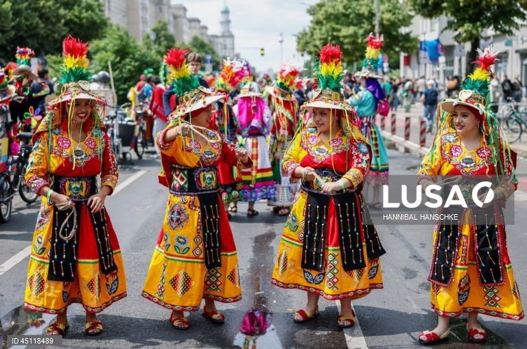 Pessoas vestem trajes tradicionais enquanto participam no Carnaval das Culturas em Berlim, Alemanha. O desfile envolve mais de 4 000 participantes que exibem as culturas dos seus países de origem. O Carnaval das Culturas é celebrado anualmente em Berlim desde 1996 e pretende ser um símbolo da diversidade e da coexistência pacífica. 