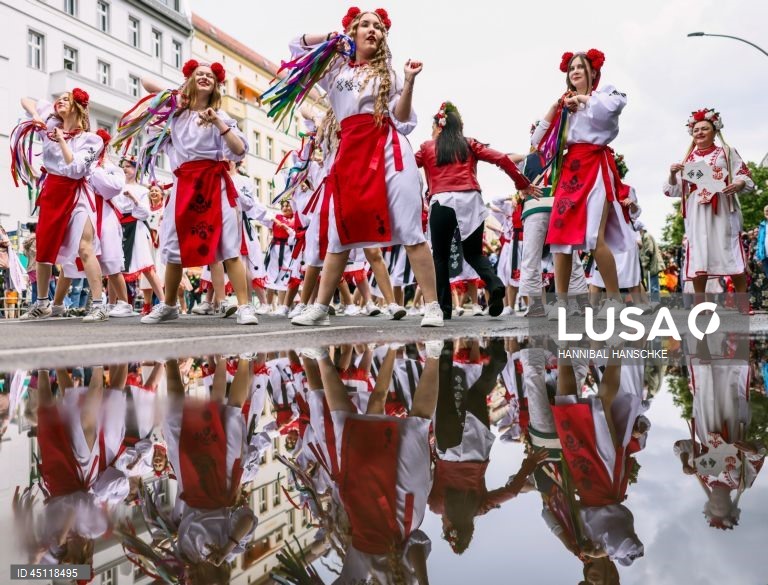 Pessoas vestem trajes tradicionais enquanto participam no Carnaval das Culturas em Berlim, Alemanha. O desfile envolve mais de 4 000 participantes que exibem as culturas dos seus países de origem. O Carnaval das Culturas é celebrado anualmente em Berlim desde 1996 e pretende ser um símbolo da diversidade e da coexistência pacífica. 