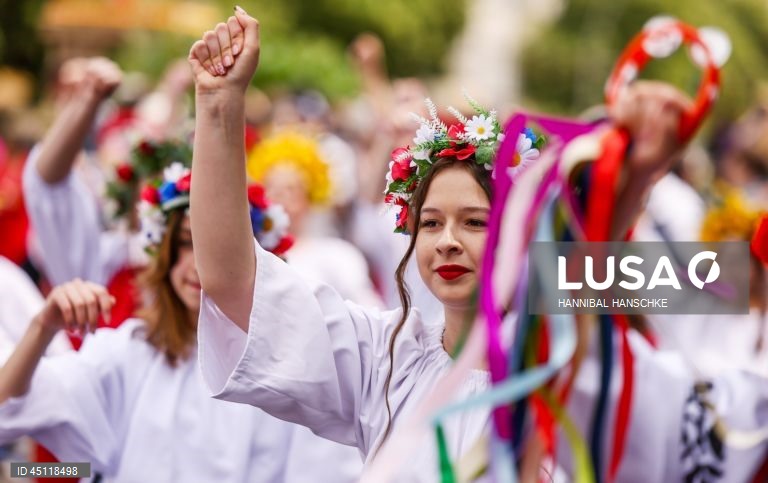 Pessoas vestem trajes tradicionais enquanto participam no Carnaval das Culturas em Berlim, Alemanha. O desfile envolve mais de 4 000 participantes que exibem as culturas dos seus países de origem. O Carnaval das Culturas é celebrado anualmente em Berlim desde 1996 e pretende ser um símbolo da diversidade e da coexistência pacífica. 