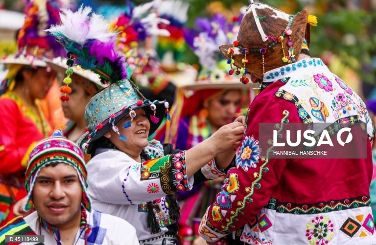 Pessoas vestem trajes tradicionais enquanto participam no Carnaval das Culturas em Berlim, Alemanha. O desfile envolve mais de 4 000 participantes que exibem as culturas dos seus países de origem. O Carnaval das Culturas é celebrado anualmente em Berlim desde 1996 e pretende ser um símbolo da diversidade e da coexistência pacífica. 